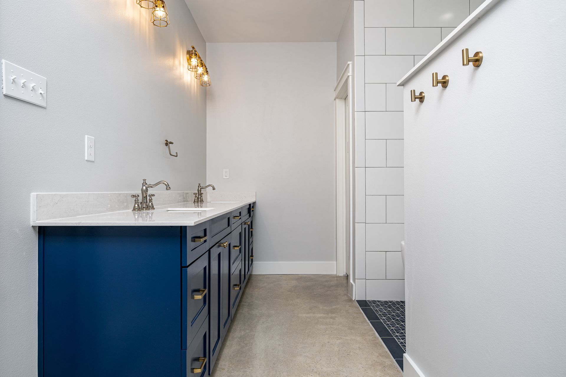 A bathroom with two sinks and a walk in closet.