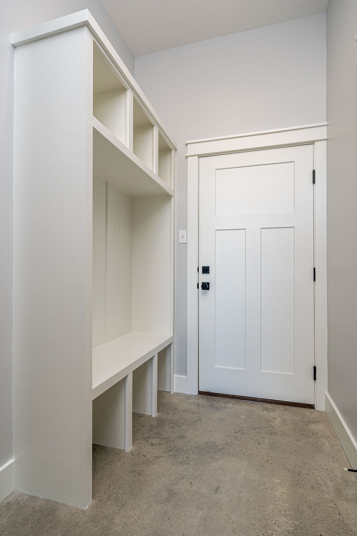 A hallway with a bench and a door in a house.