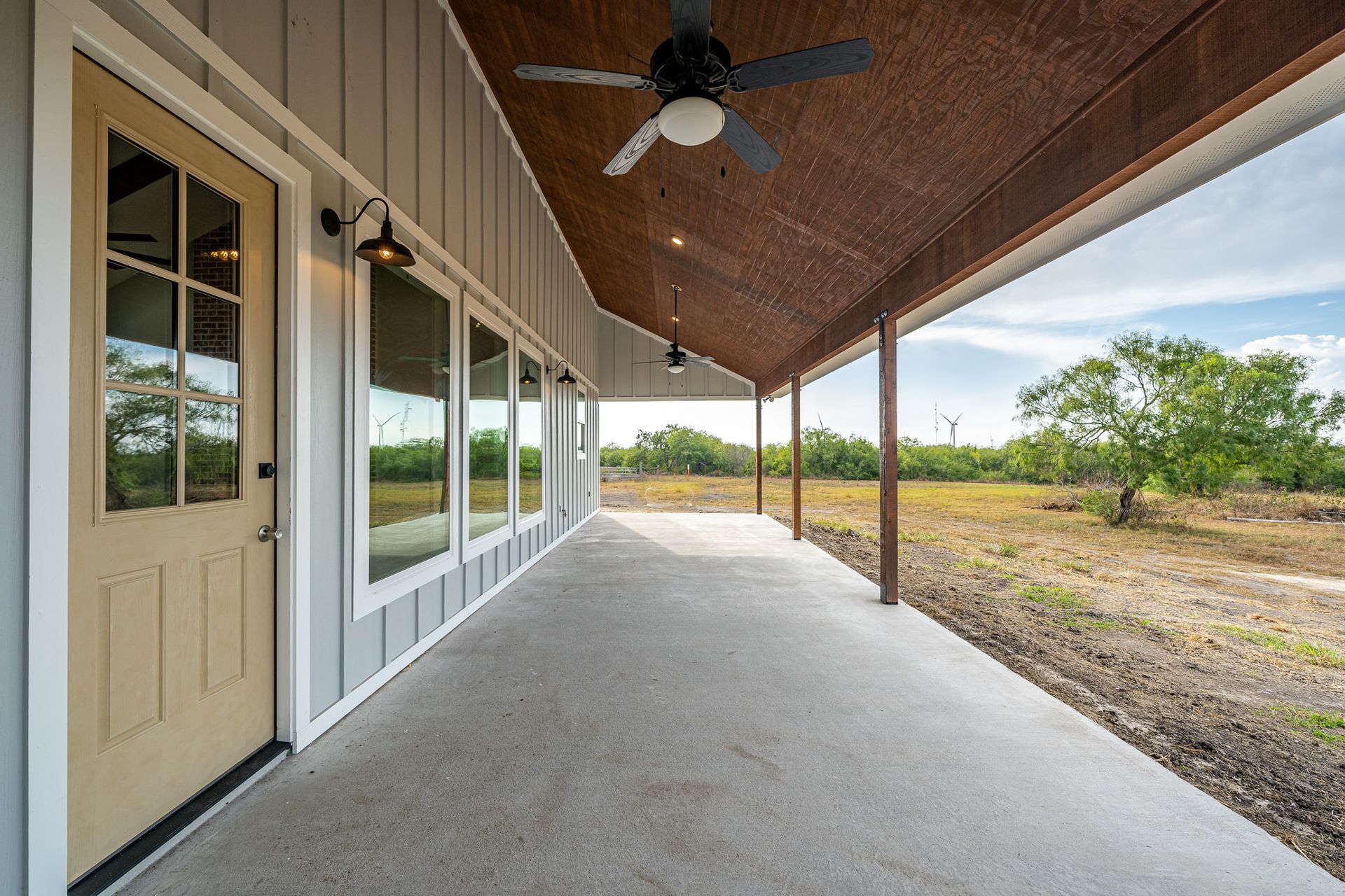 There is a ceiling fan on the porch of a house.