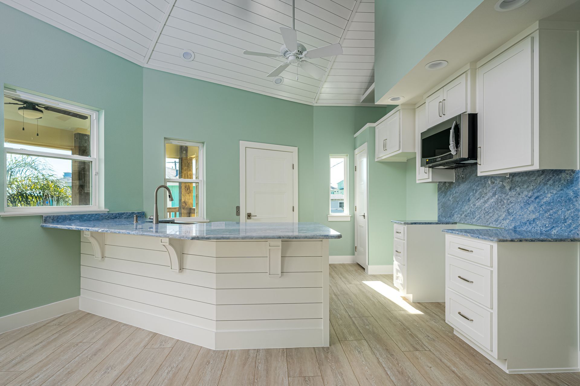 A kitchen with white cabinets and blue counter tops