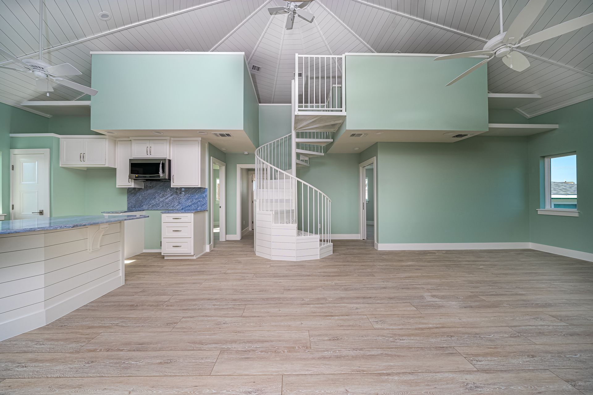 An empty house with a spiral staircase leading to the second floor