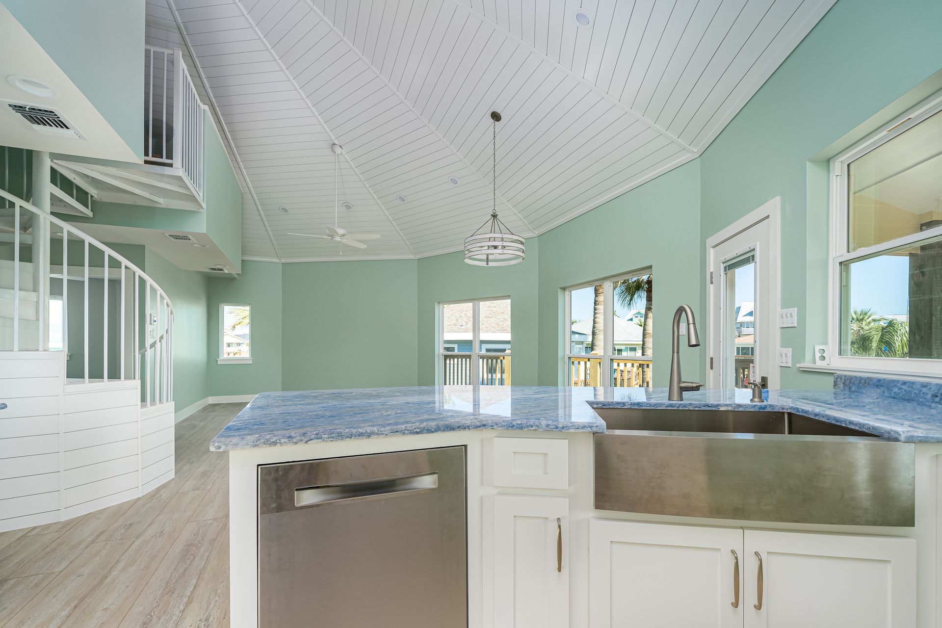 A kitchen with white cabinets and a stainless steel sink