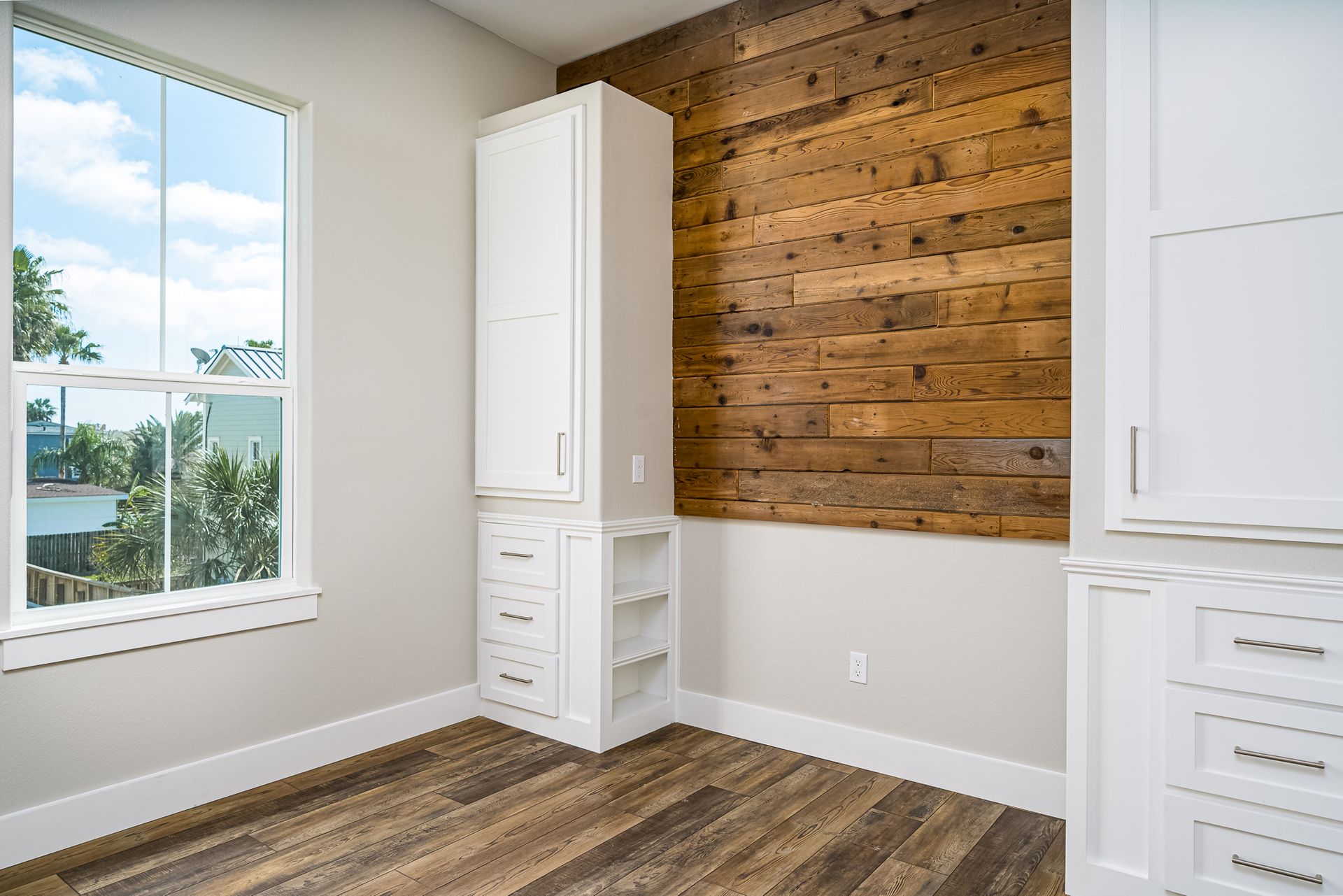 There is a wooden wall in the room with a window.