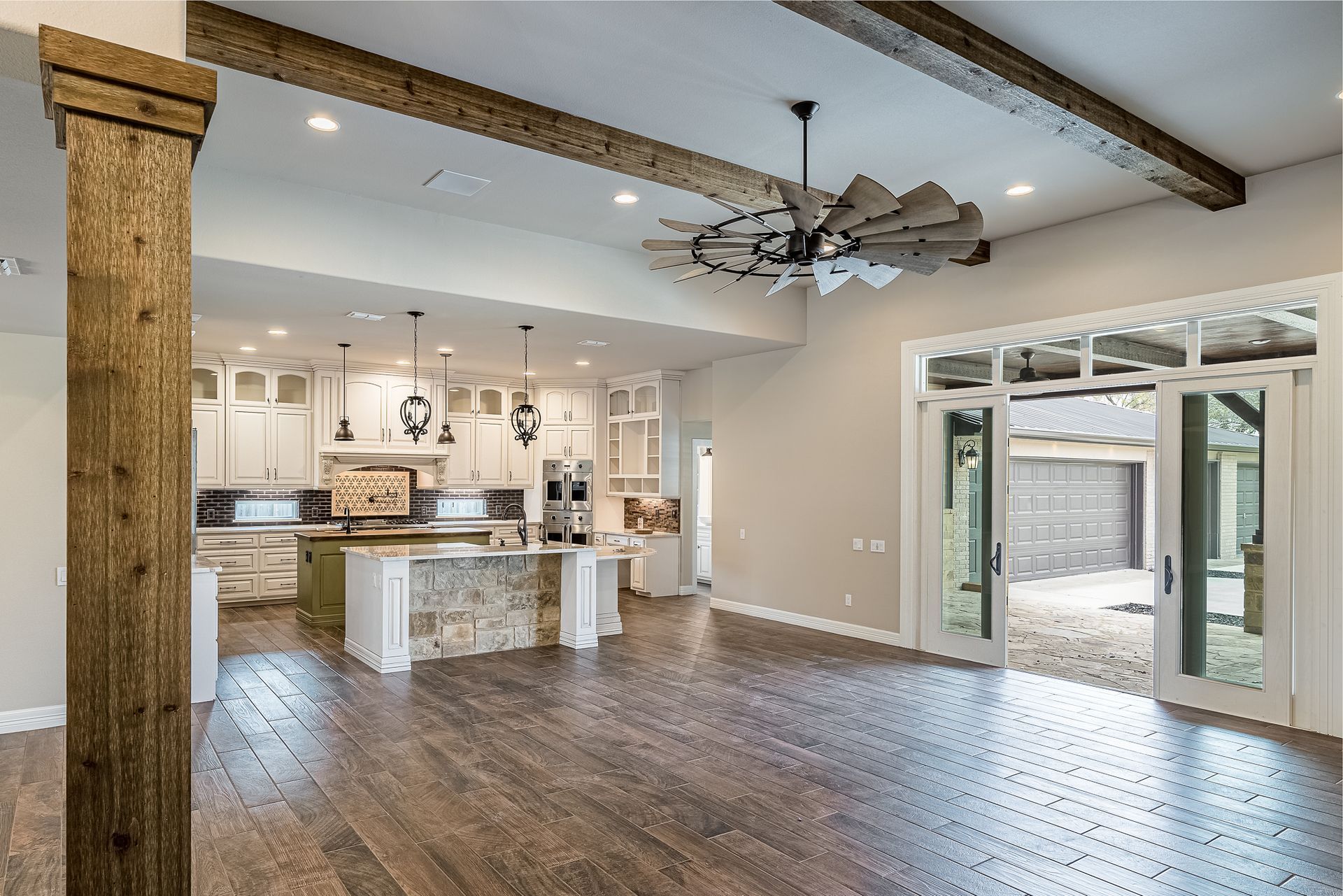 A large empty room with hardwood floors and a ceiling fan.