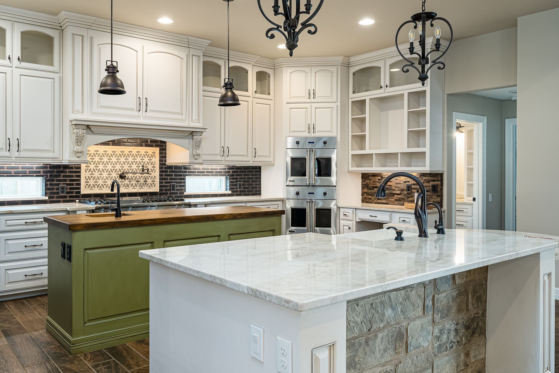 A kitchen with white cabinets , granite counter tops , and a large island.