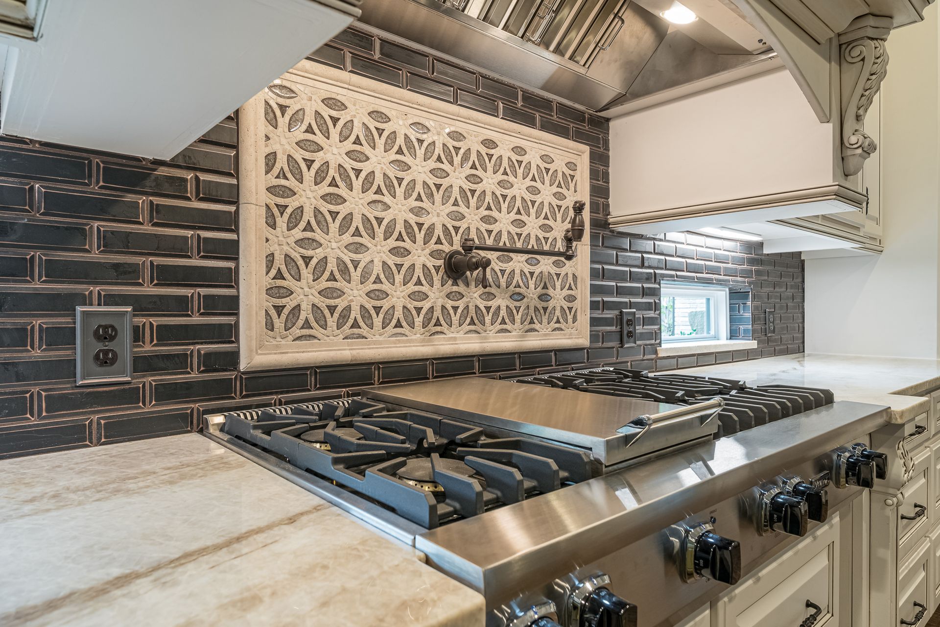 A stove top oven in a kitchen with a brick wall behind it.