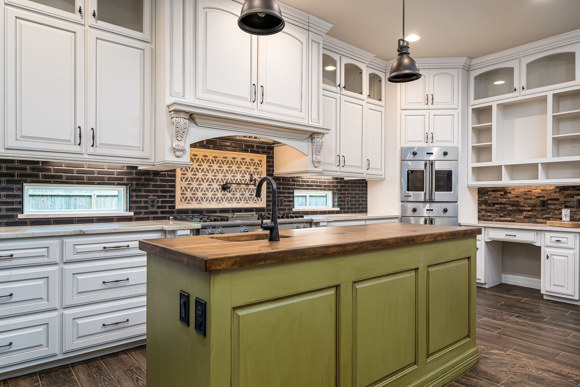 A kitchen with white cabinets and a green island.