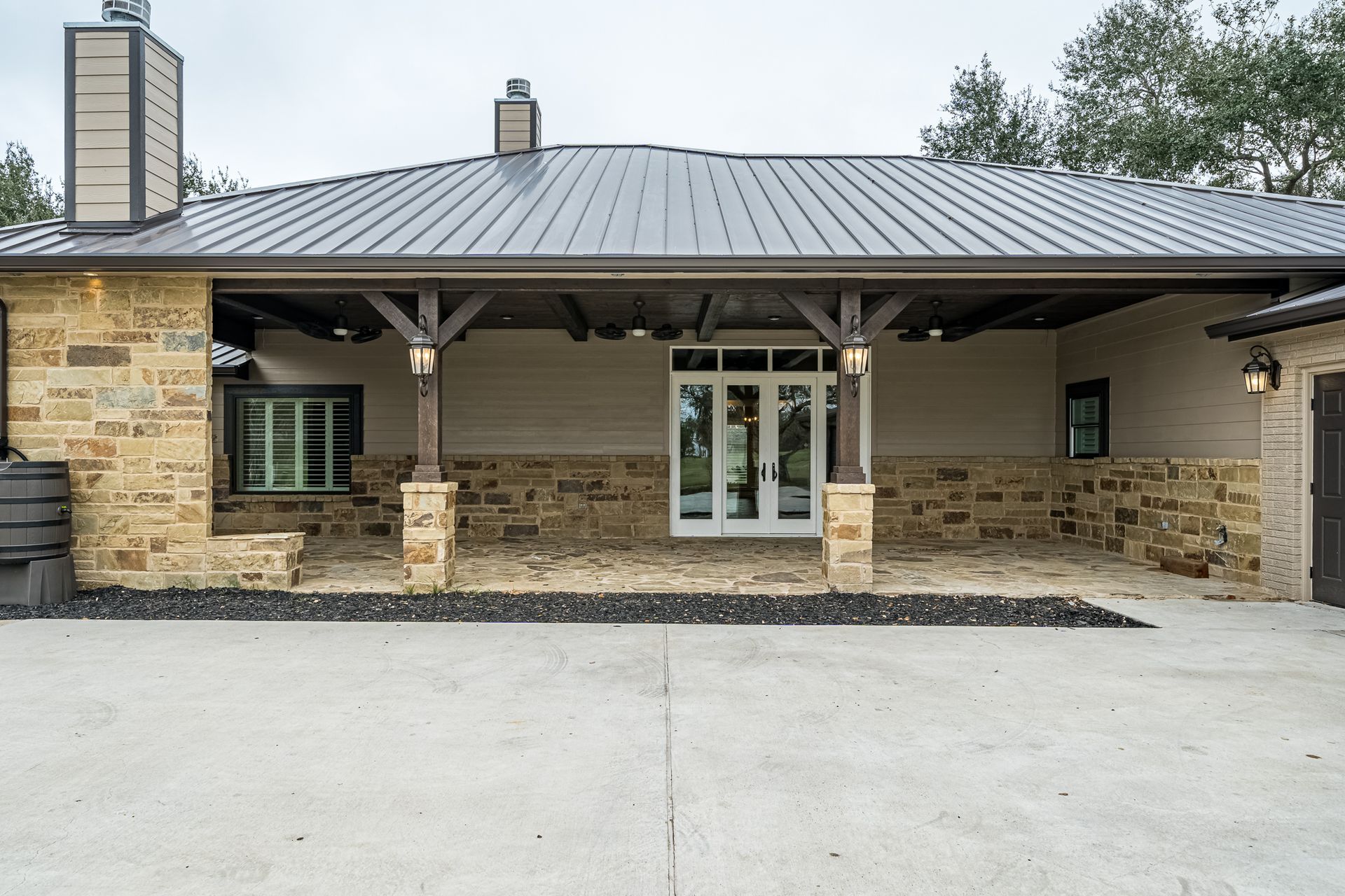 A large house with a covered porch and a metal roof