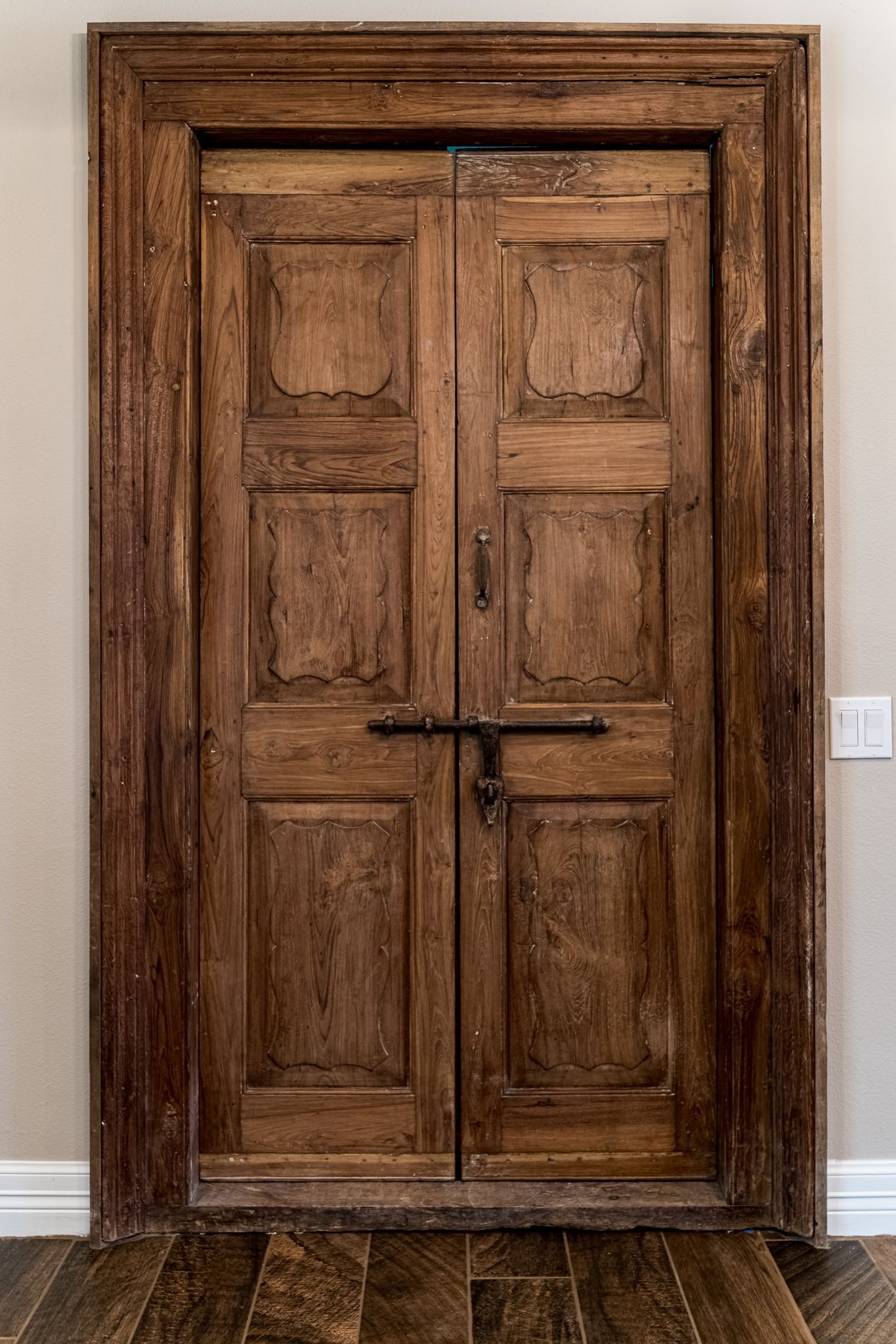A wooden door with a lock on it is in a room.