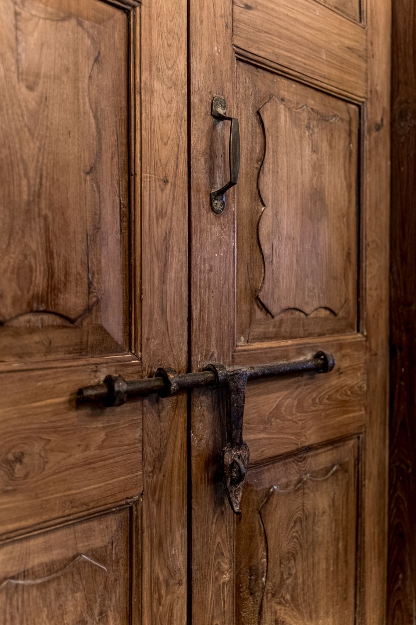 A close up of a wooden door with a metal latch.