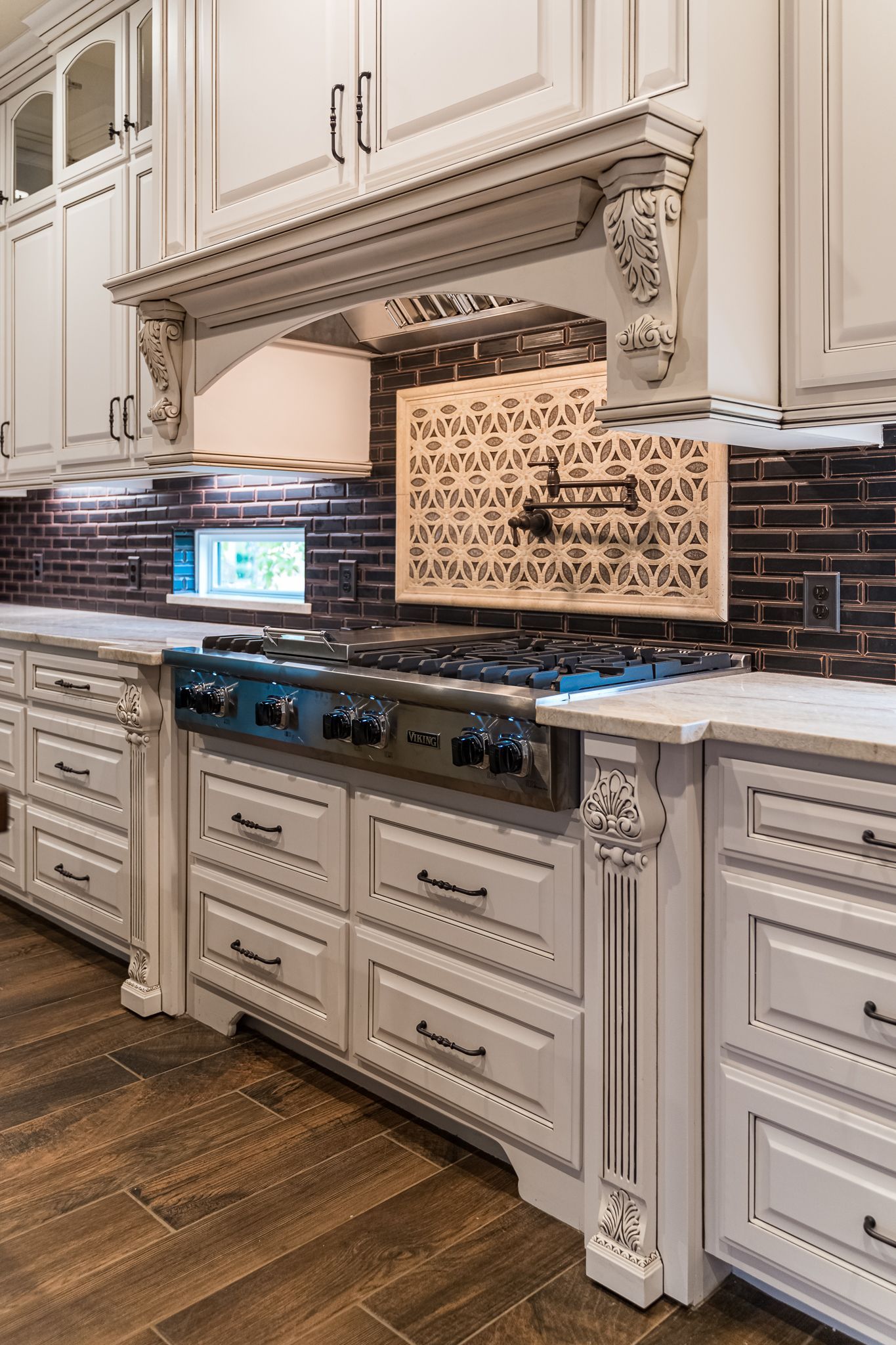 A kitchen with white cabinets and a stove top oven.