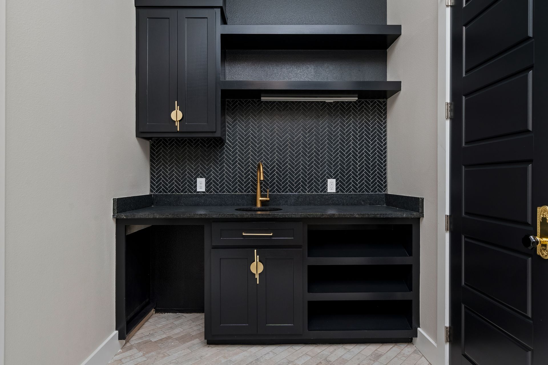 A kitchen with black cabinets and shelves and a sink