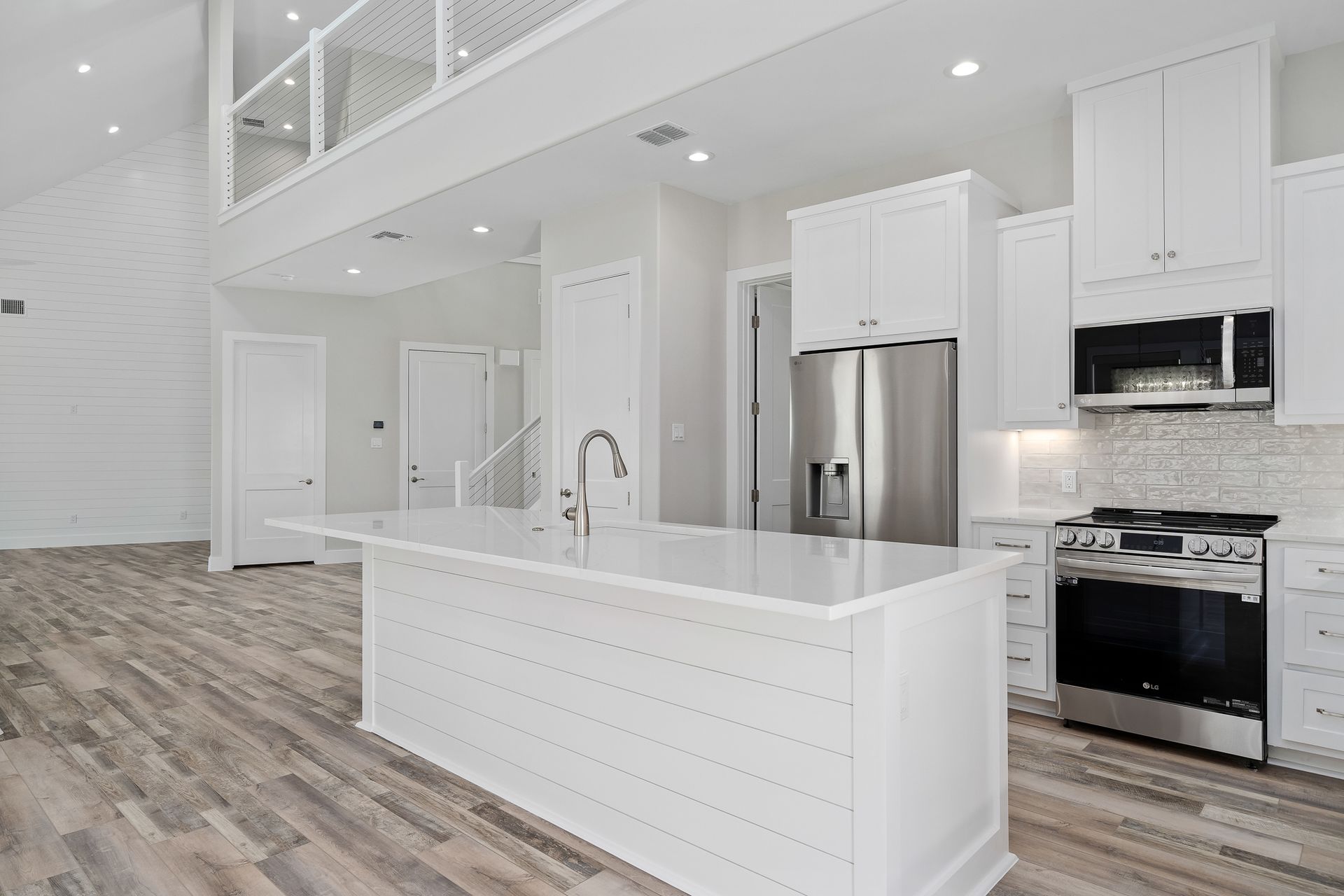 A kitchen with white cabinets and stainless steel appliances
