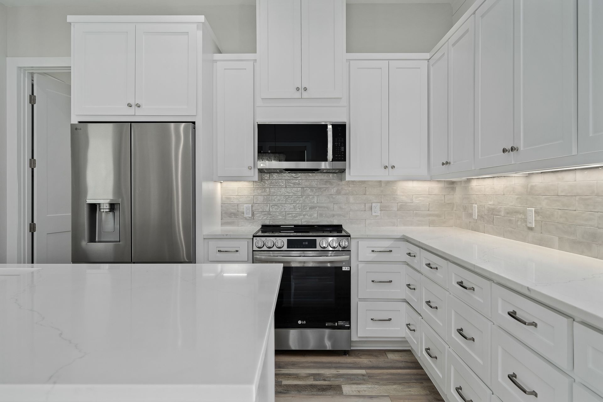 A kitchen with white cabinets and stainless steel appliances.