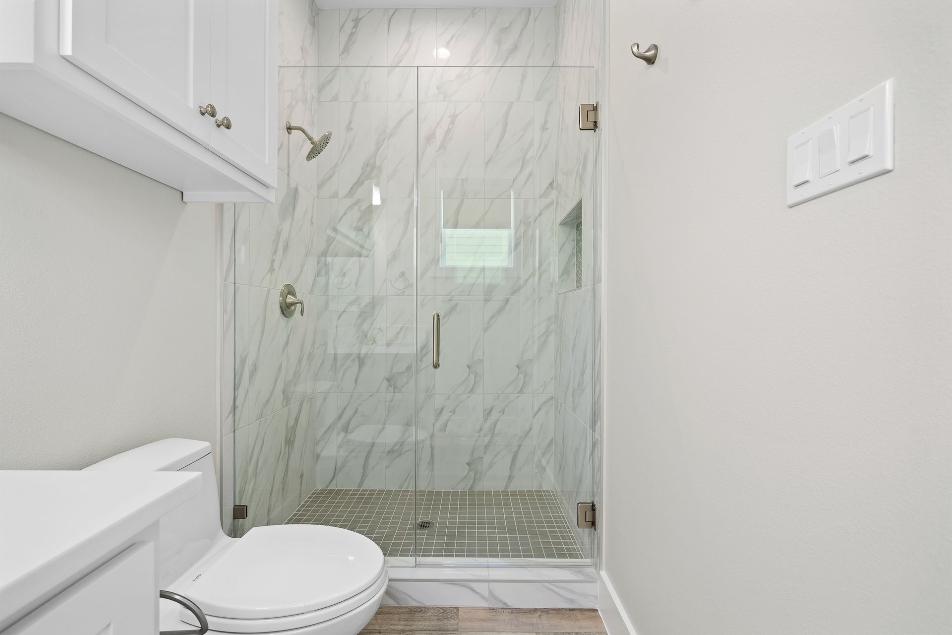 A bathroom with a toilet and a walk in shower.