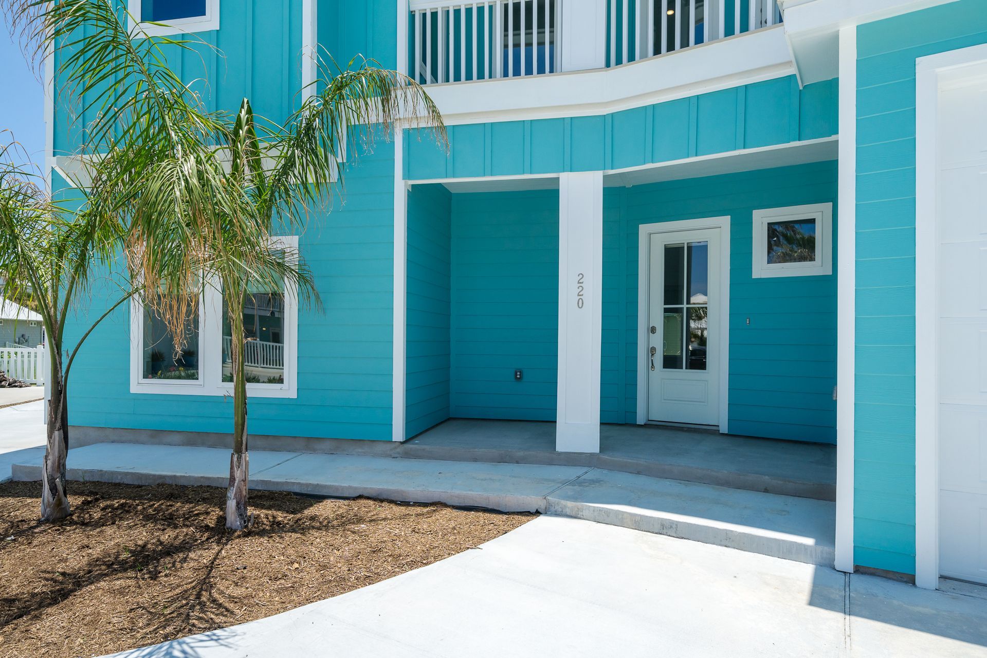 A blue and white house with a garage and a porch