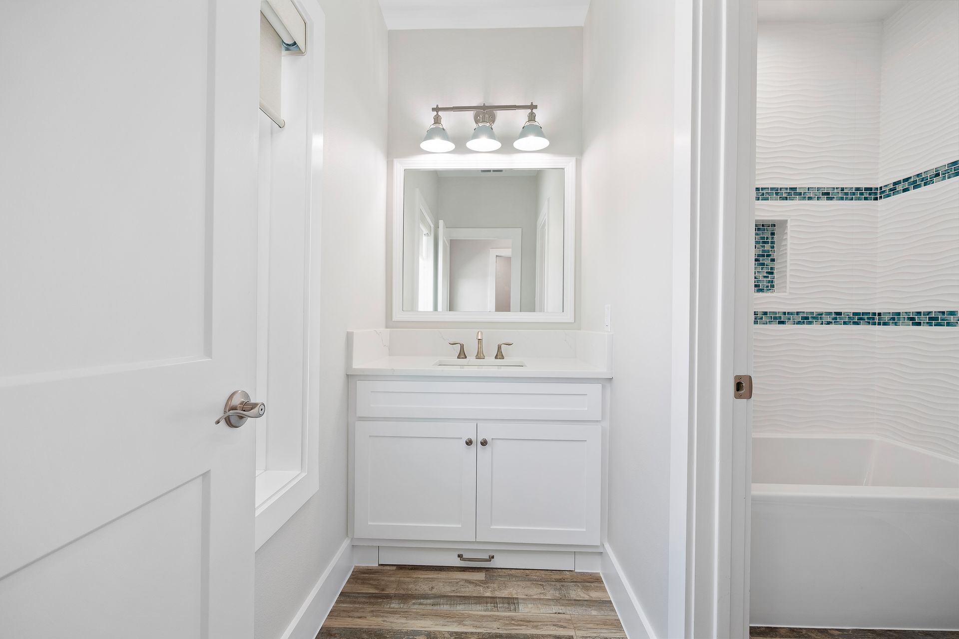A bathroom with a sink , mirror and tub.