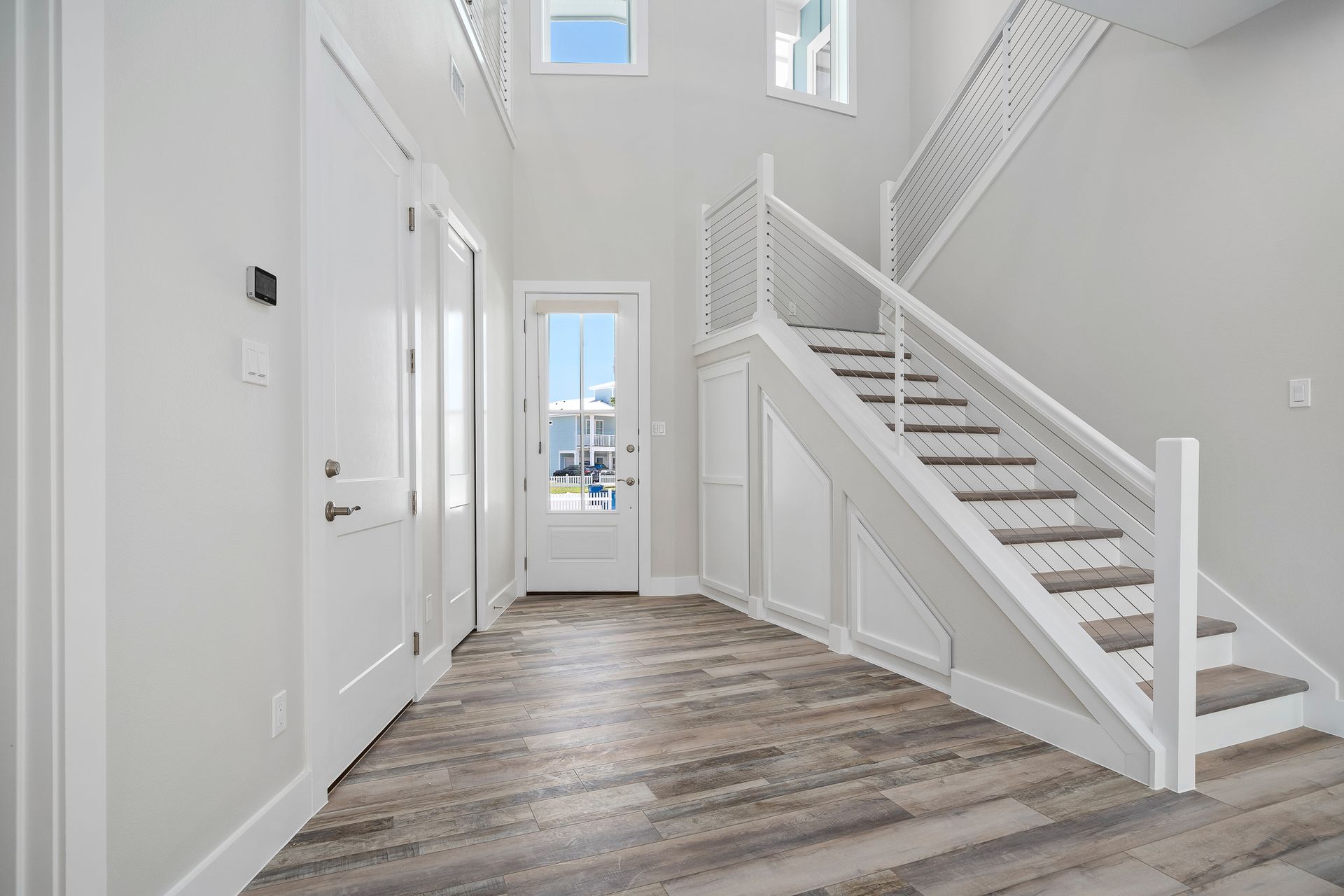 A hallway with stairs leading up to the second floor of a house.