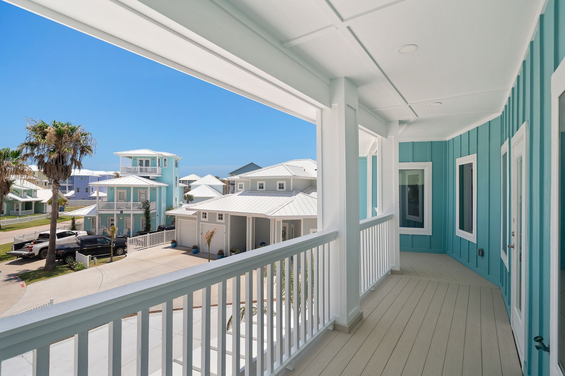A balcony with a view of houses and palm trees