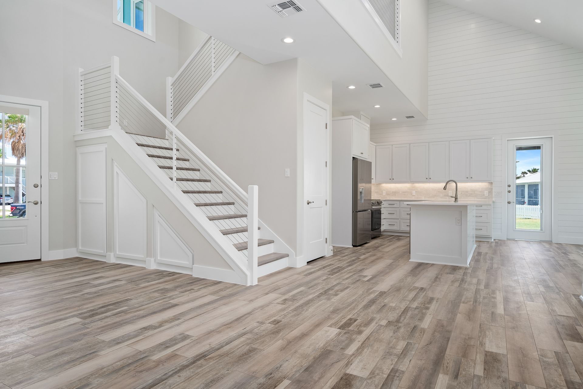 A living room with hardwood floors and stairs leading up to the second floor.