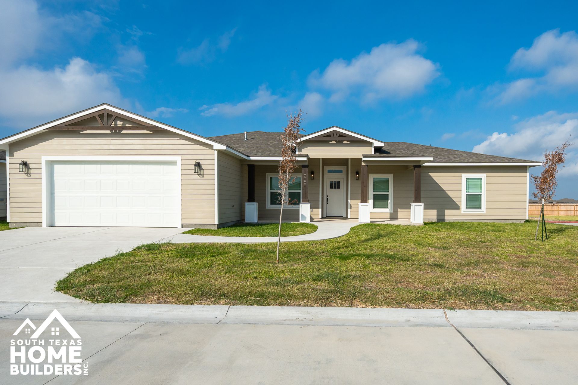 A white house with a brown garage door