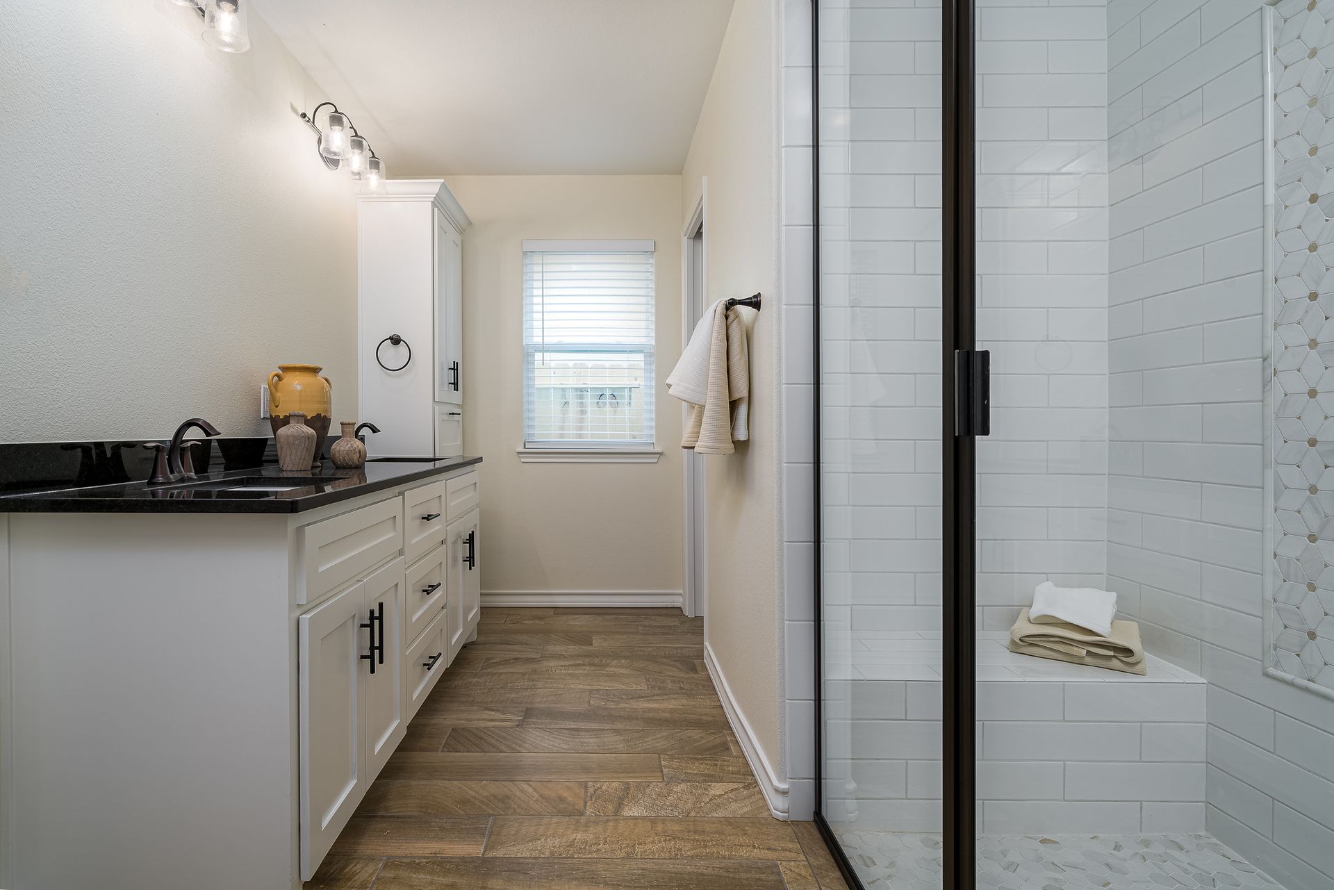 A bathroom with a walk in shower and a sink.