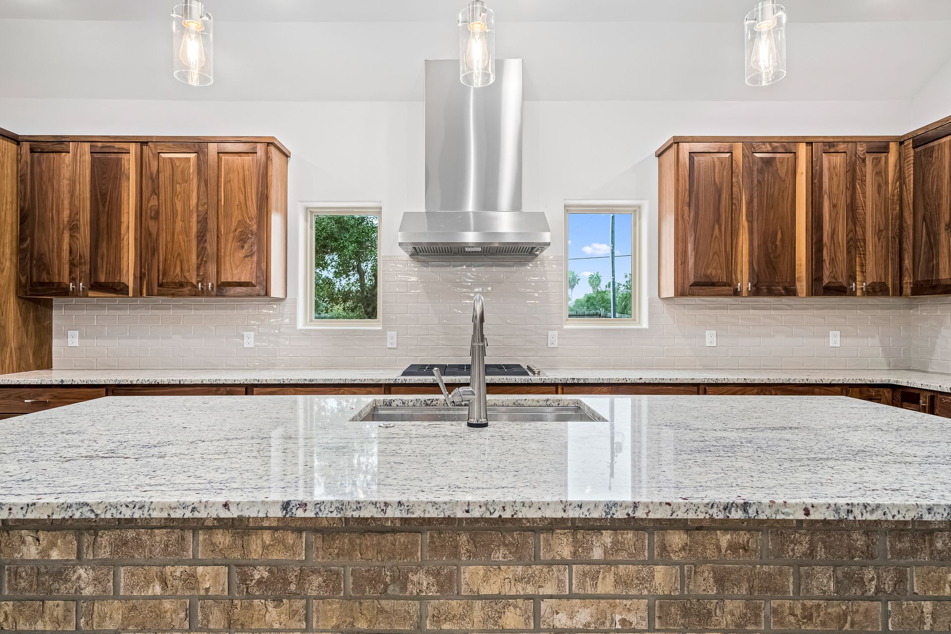 A kitchen with granite counter tops , stainless steel appliances , and wooden cabinets.