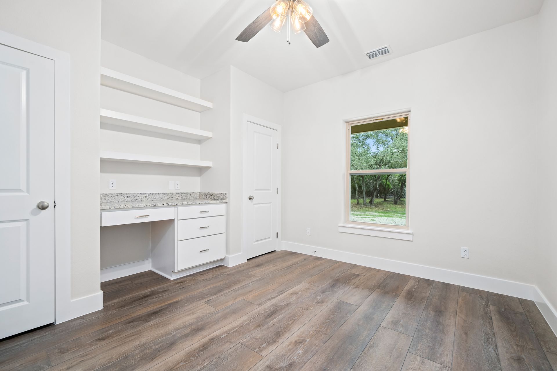 There is a ceiling fan in the room and a window.