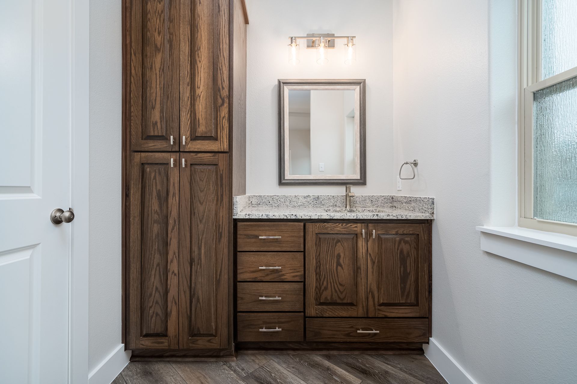 A bathroom with a sink , mirror and cabinets.