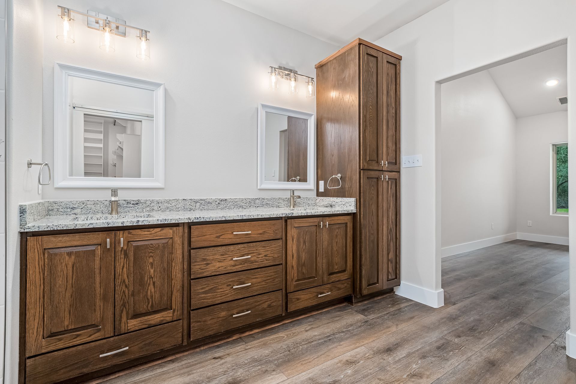 A bathroom with two sinks and two mirrors in a house.