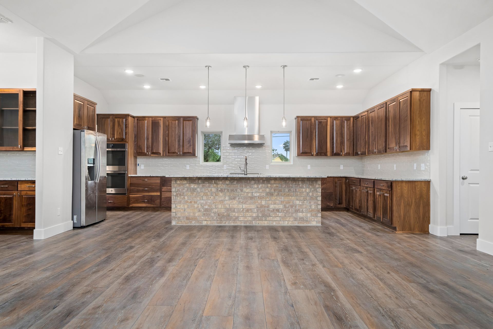 An empty living room with hardwood floors and a ceiling fan.