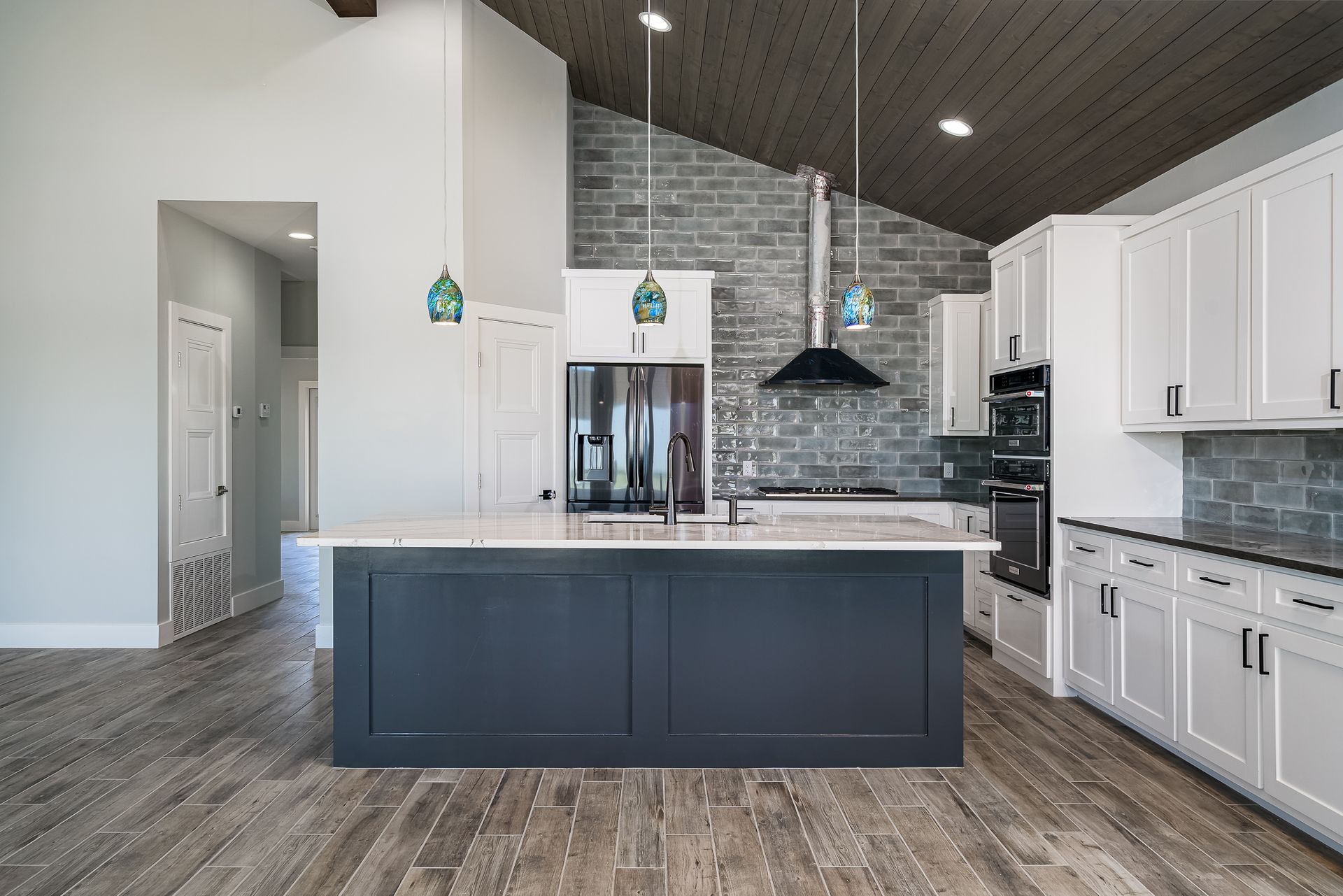 A kitchen with white cabinets and a large island in the middle.