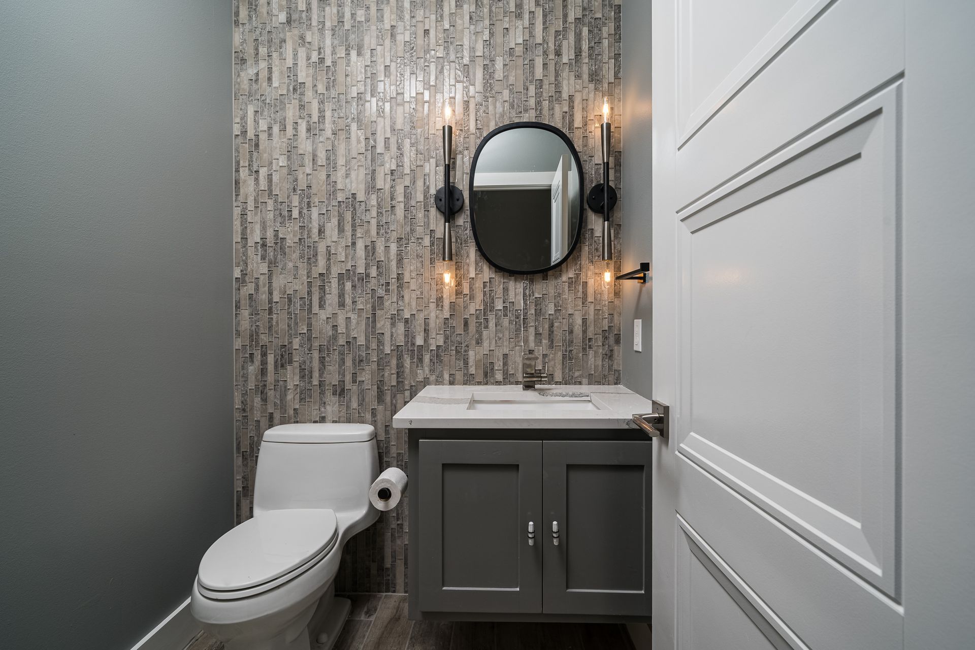 A bathroom with a toilet , sink and mirror.