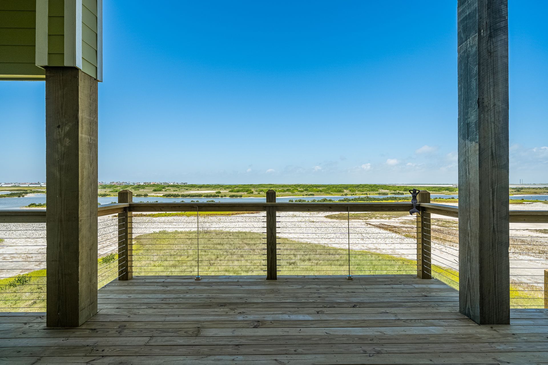 A wooden deck with a railing overlooking a body of water.