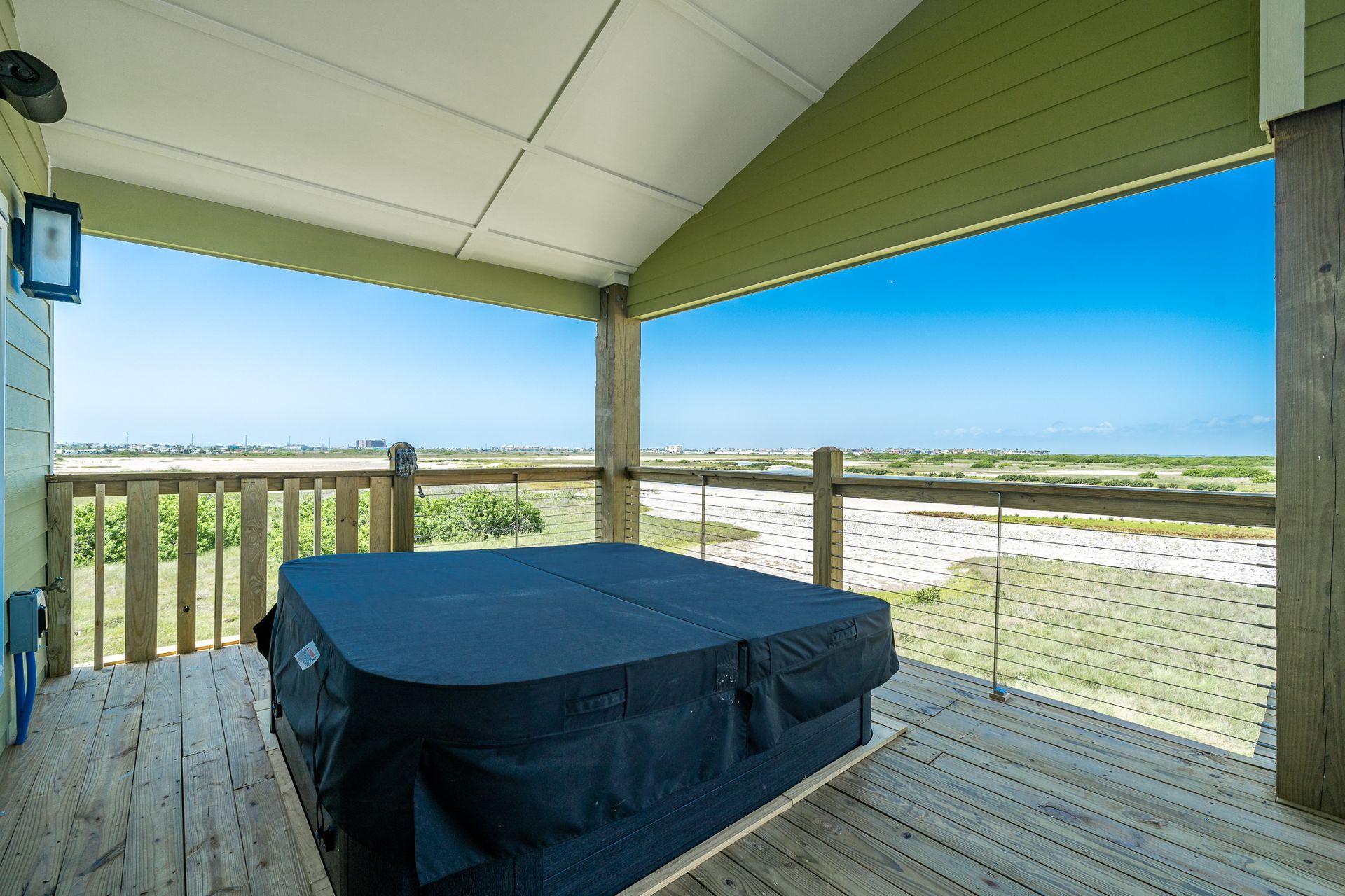 A hot tub is sitting on a deck with a view of the ocean.