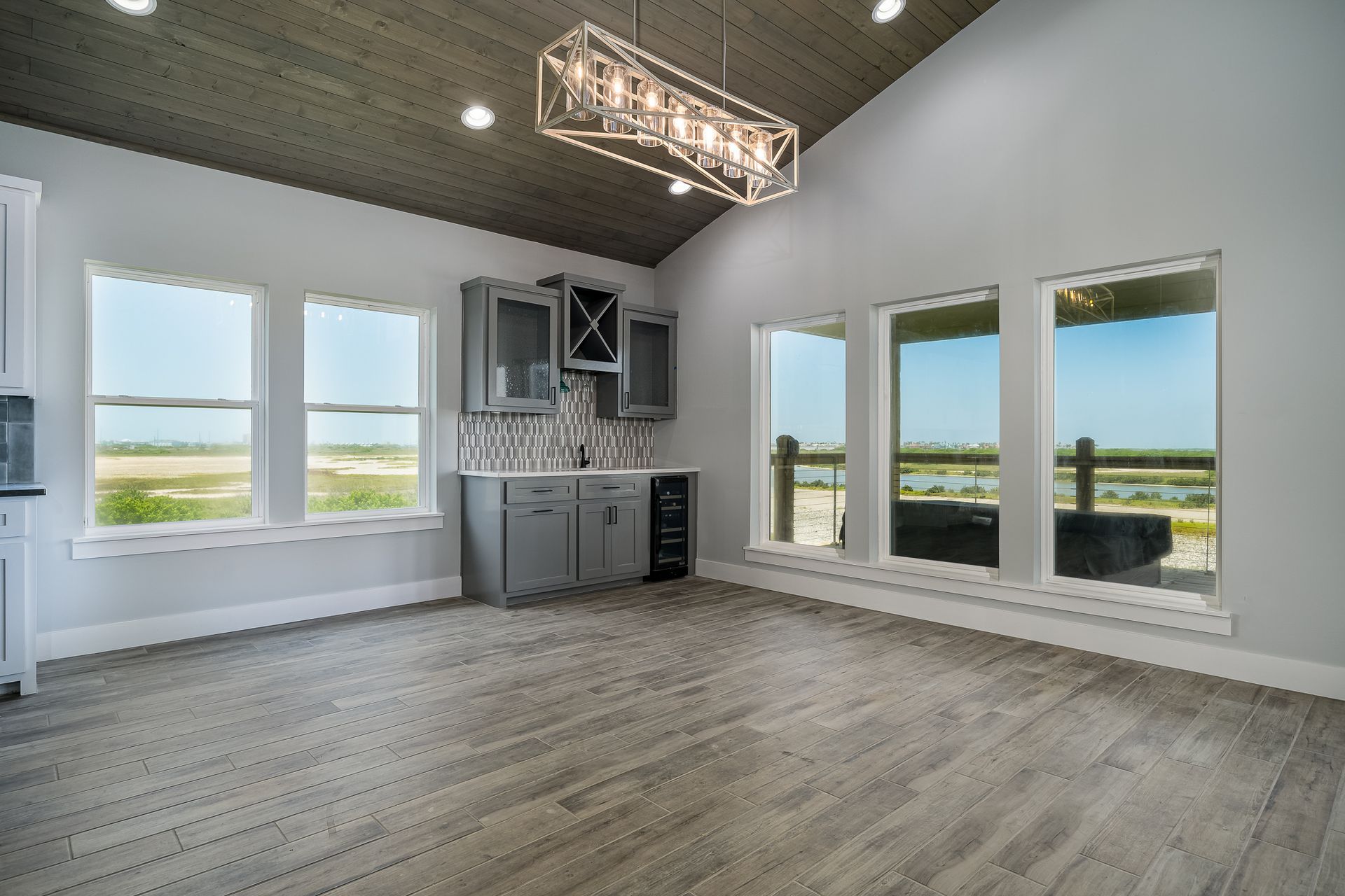A large empty room with a lot of windows and a chandelier.