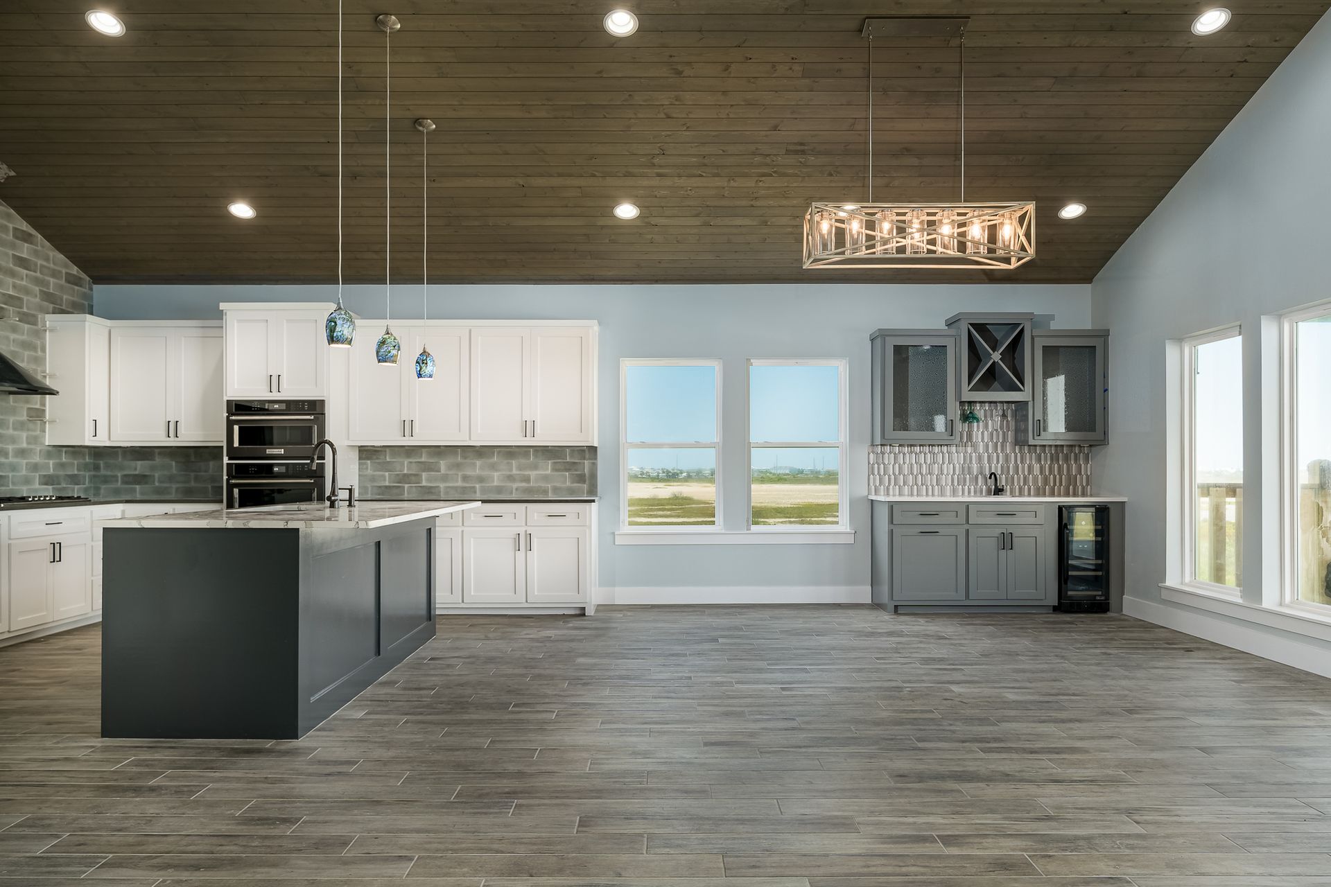An empty kitchen with white cabinets and a large island