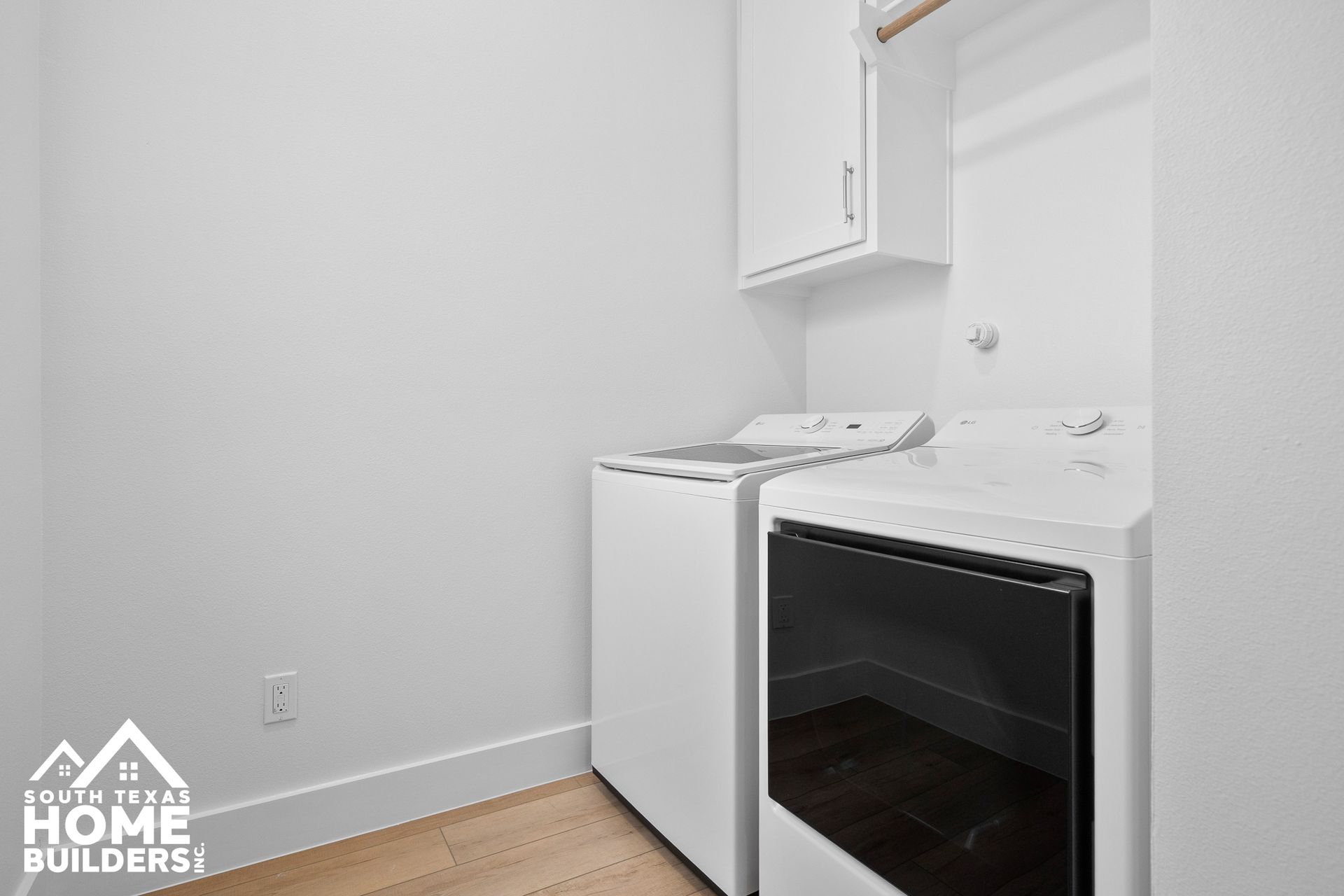 White laundry appliances in a bright, minimalist laundry room.