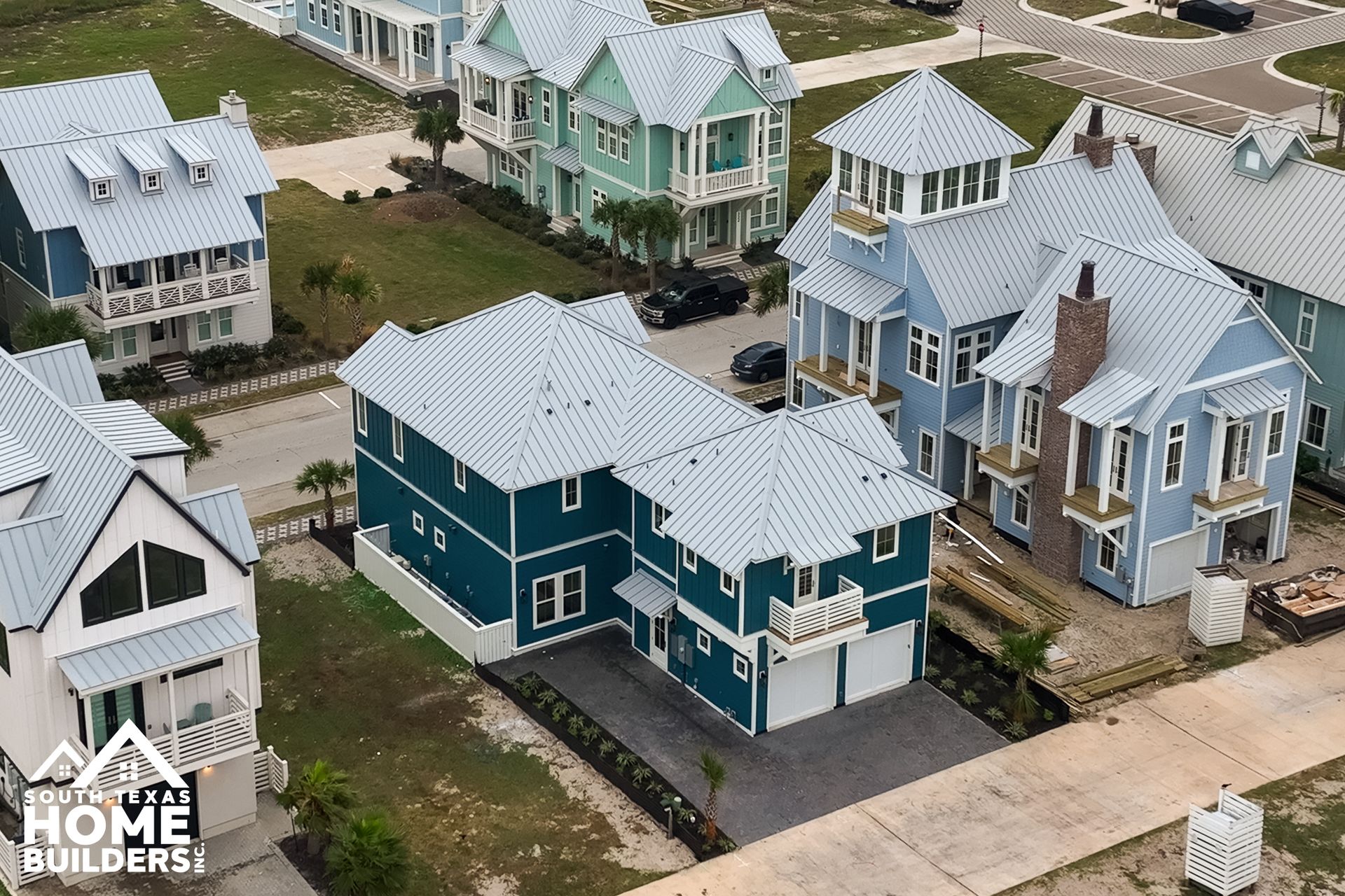 Aerial view of colorful beach houses with tin roofs.