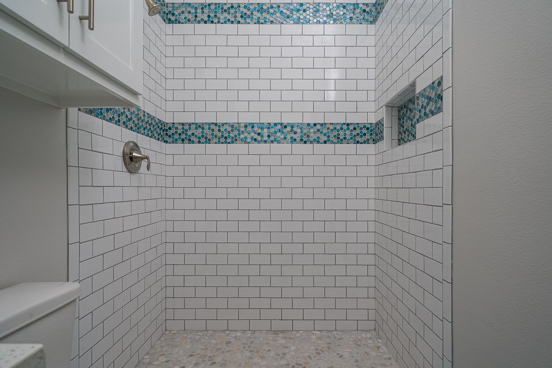 A bathroom with a walk in shower and a toilet