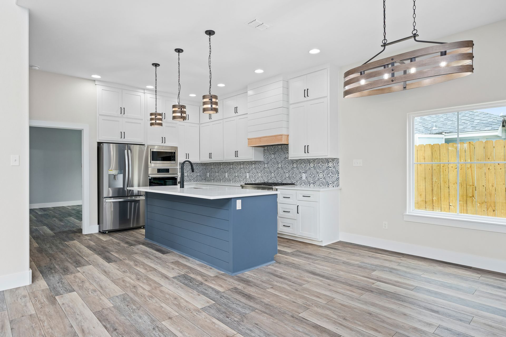 A kitchen with a blue island and stainless steel appliances