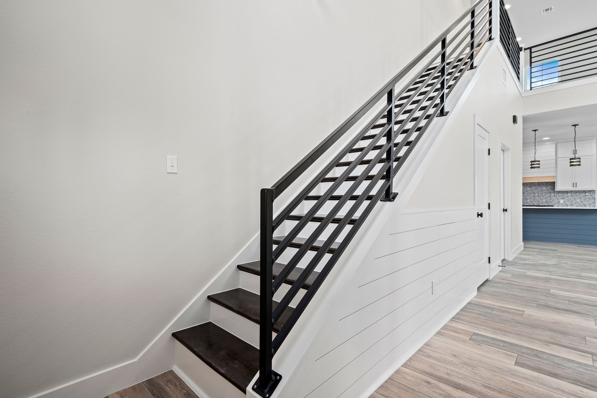 A staircase in a house with a black railing