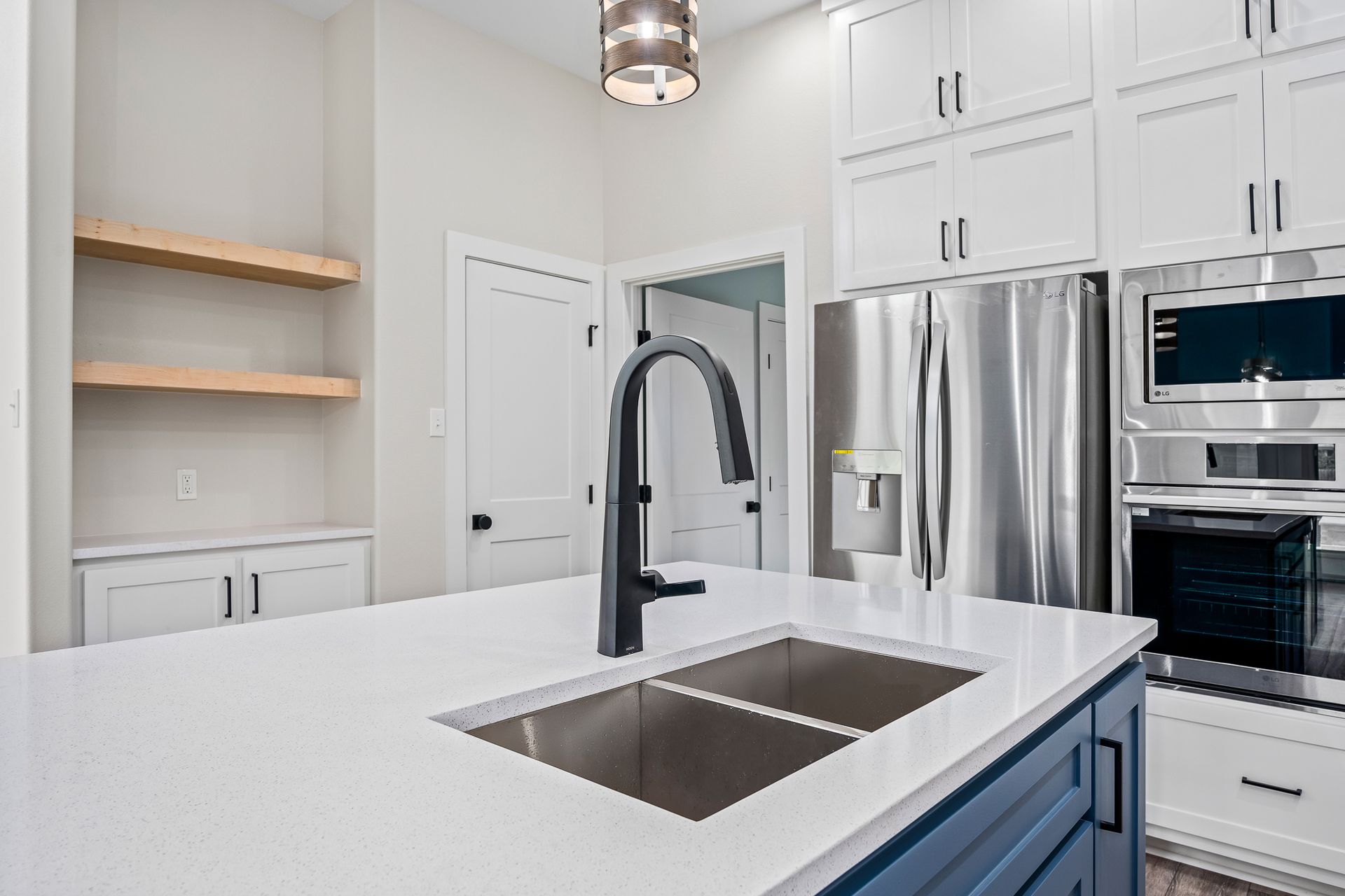 A kitchen with a sink , refrigerator , microwave and stove.