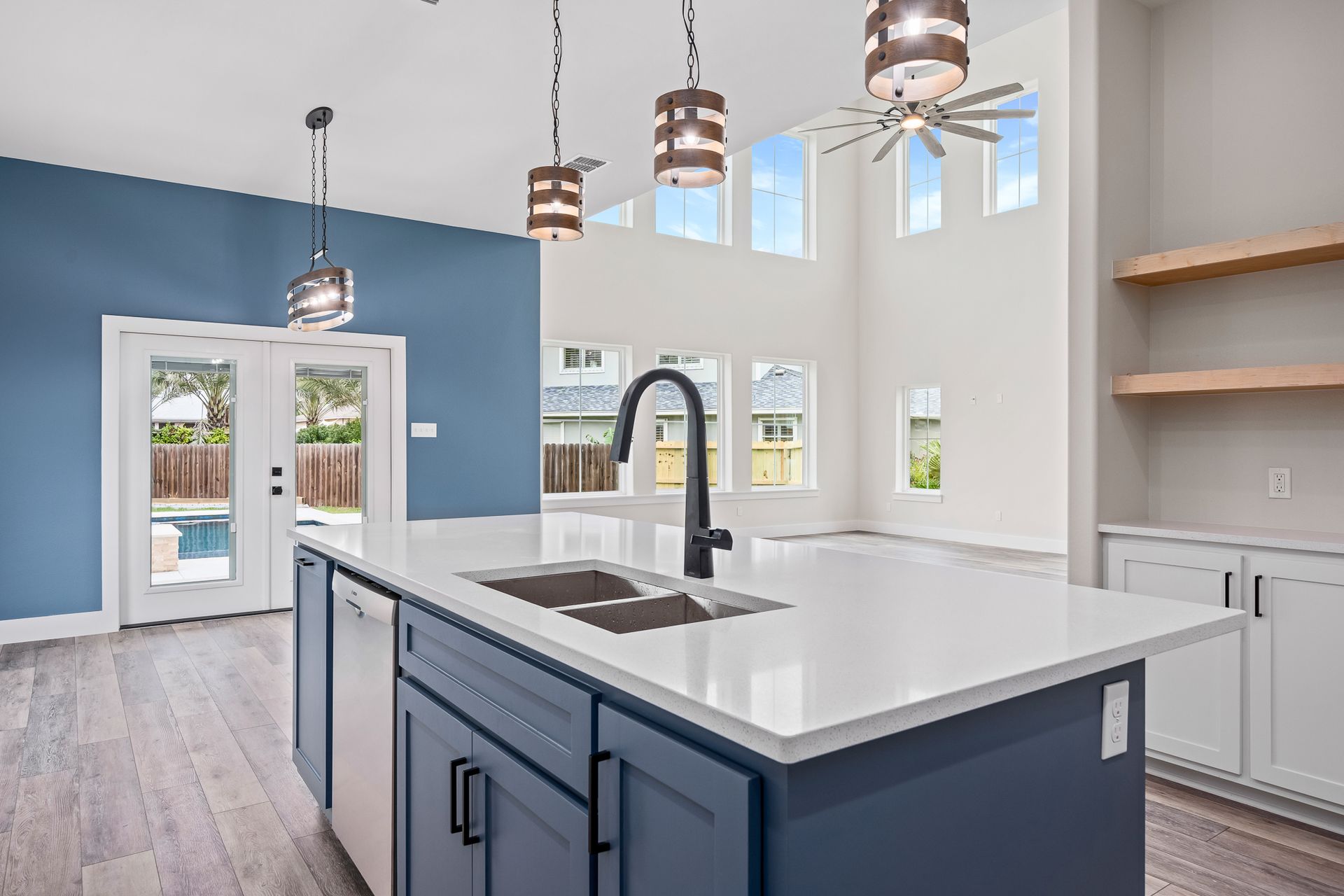 A kitchen with blue cabinets and a large island with a sink.