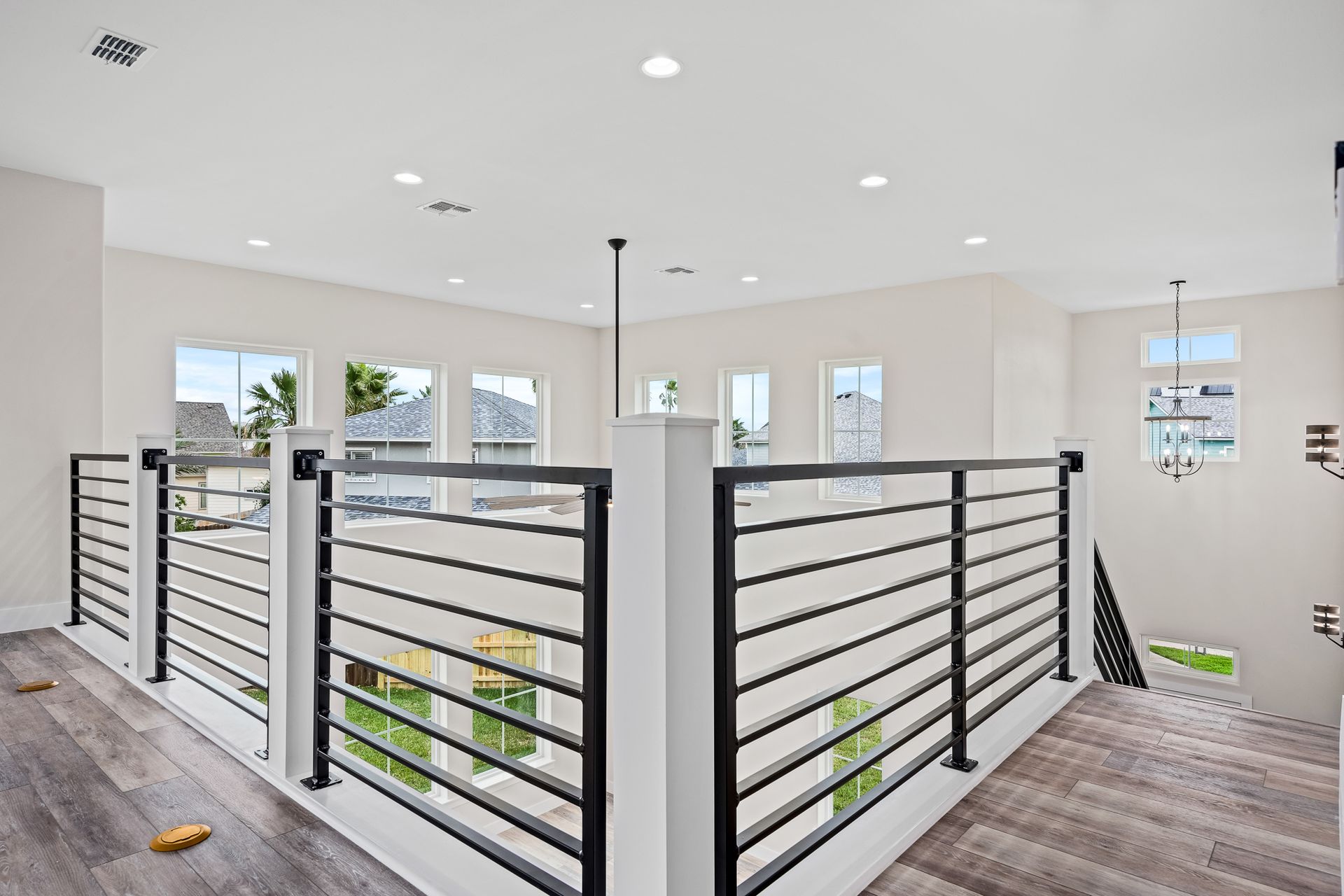 A large room with a black railing and a lot of windows.