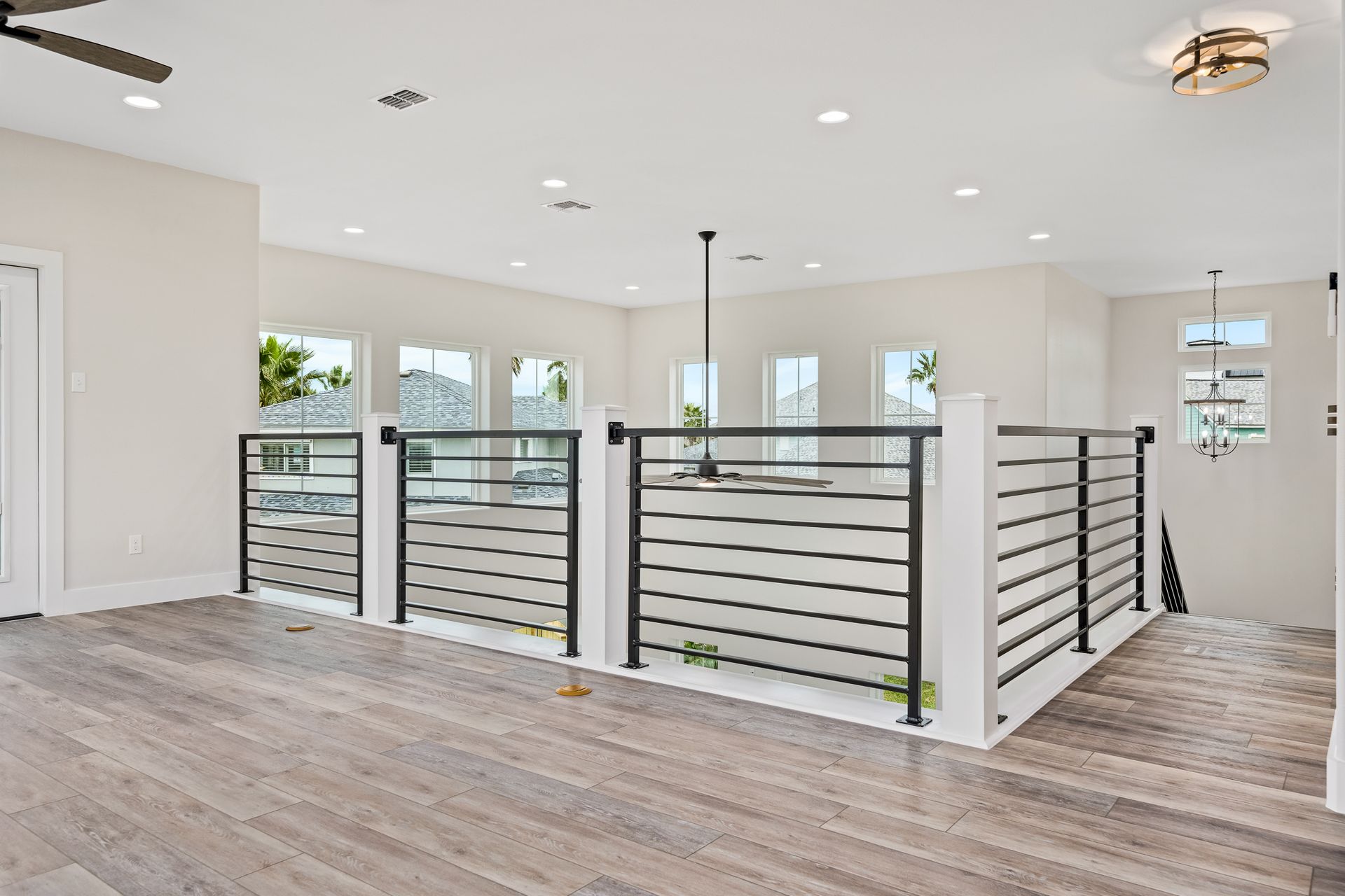 A living room with hardwood floors and a ceiling fan.
