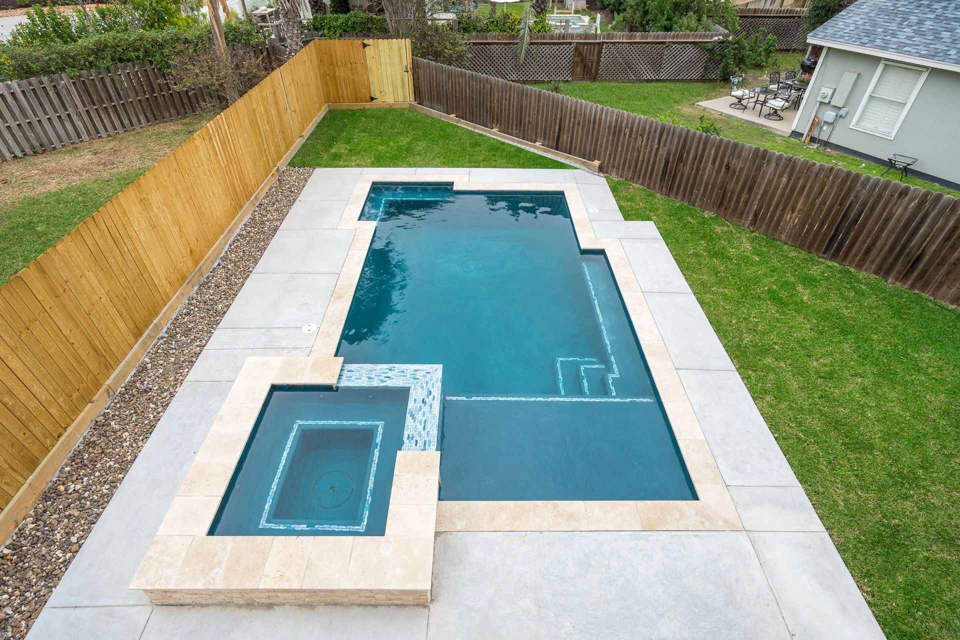 An aerial view of a large swimming pool in a backyard.