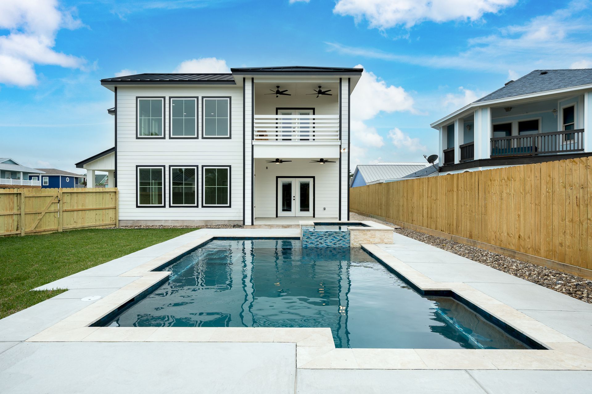 A large white house with a large swimming pool in front of it.