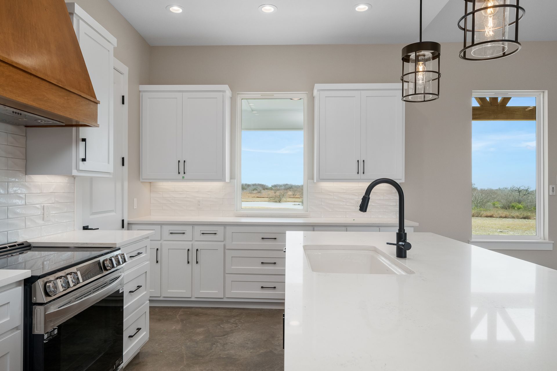 A kitchen with white cabinets , a stove and a sink