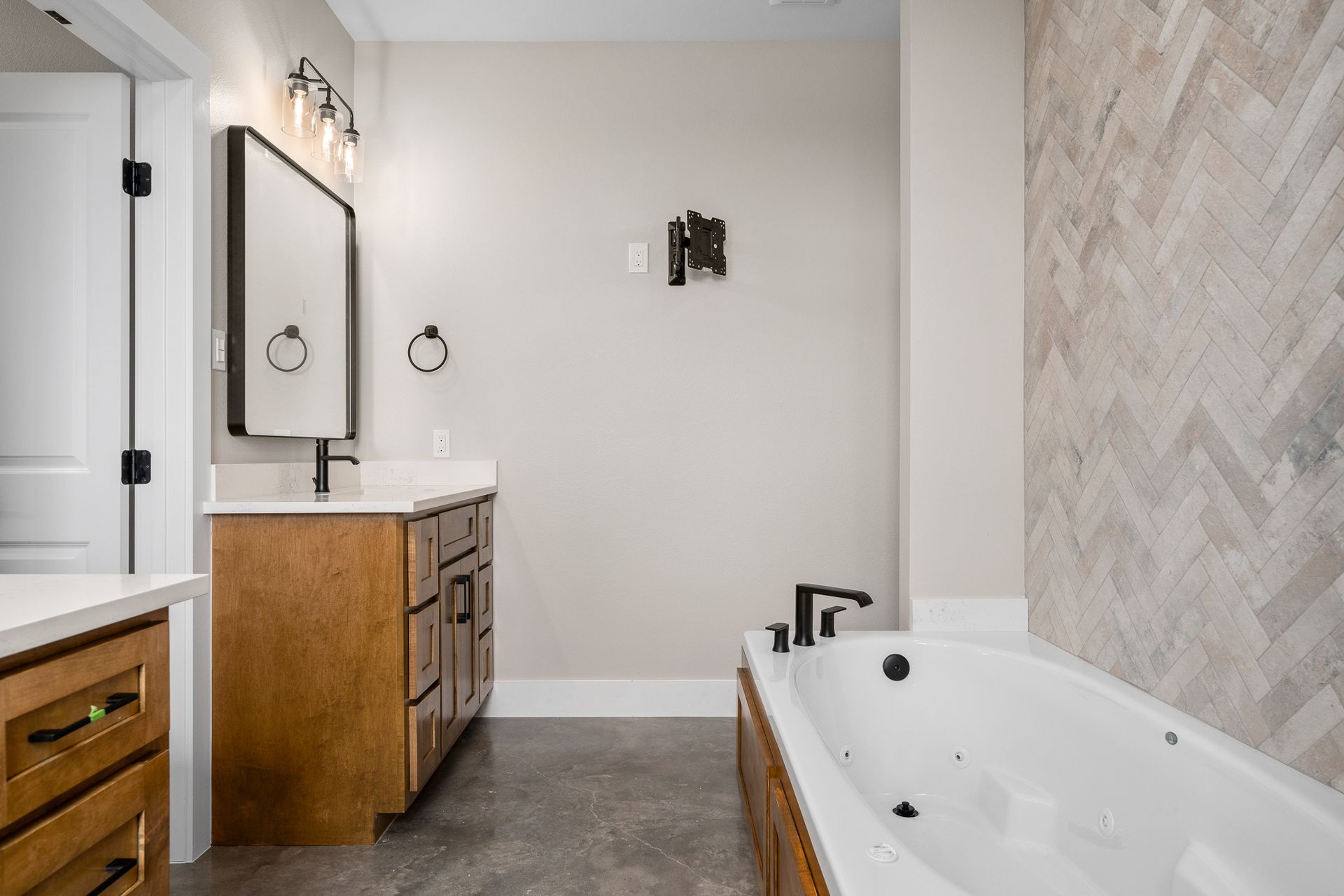 A bathroom with a tub , sink and mirror.